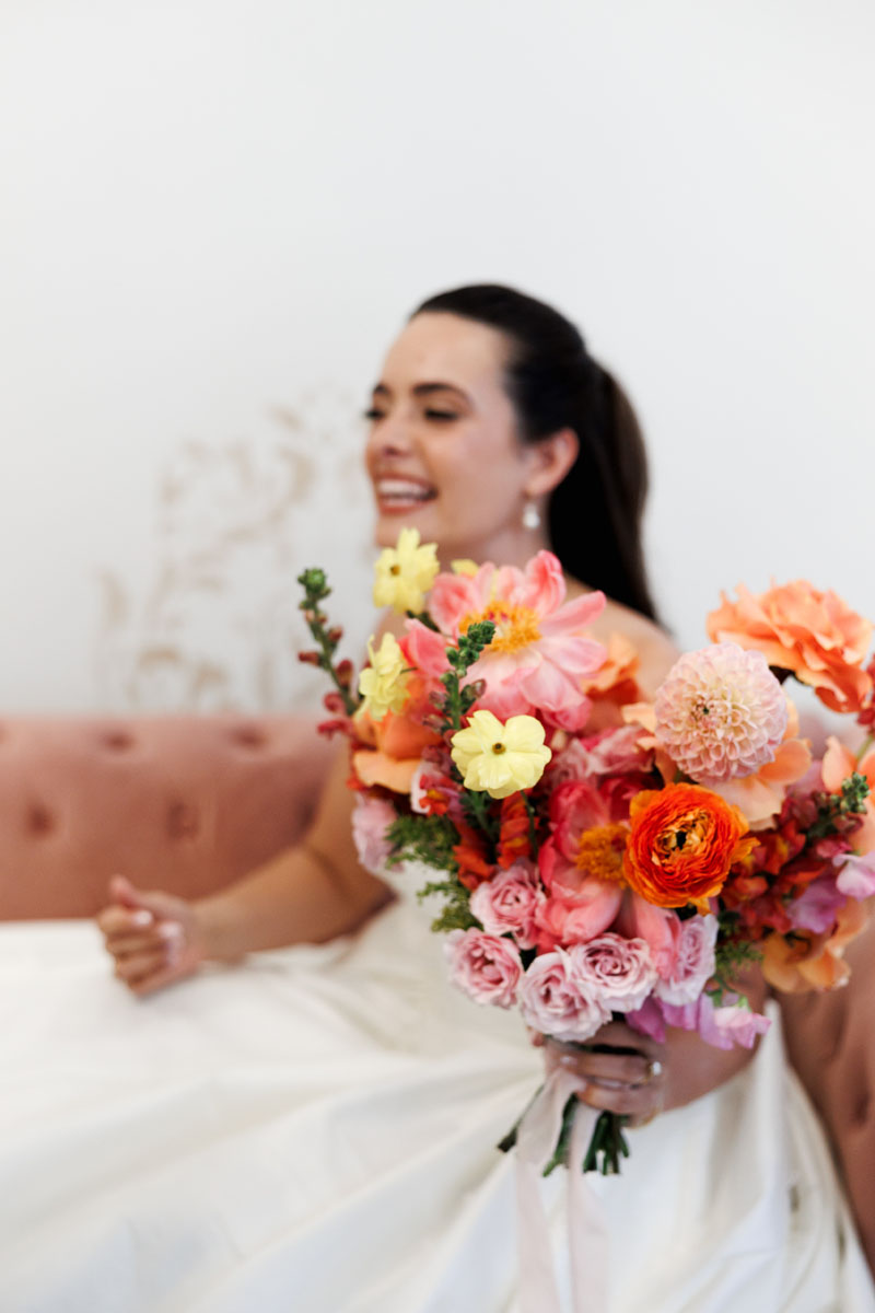 A laughing bride holding her bouquet