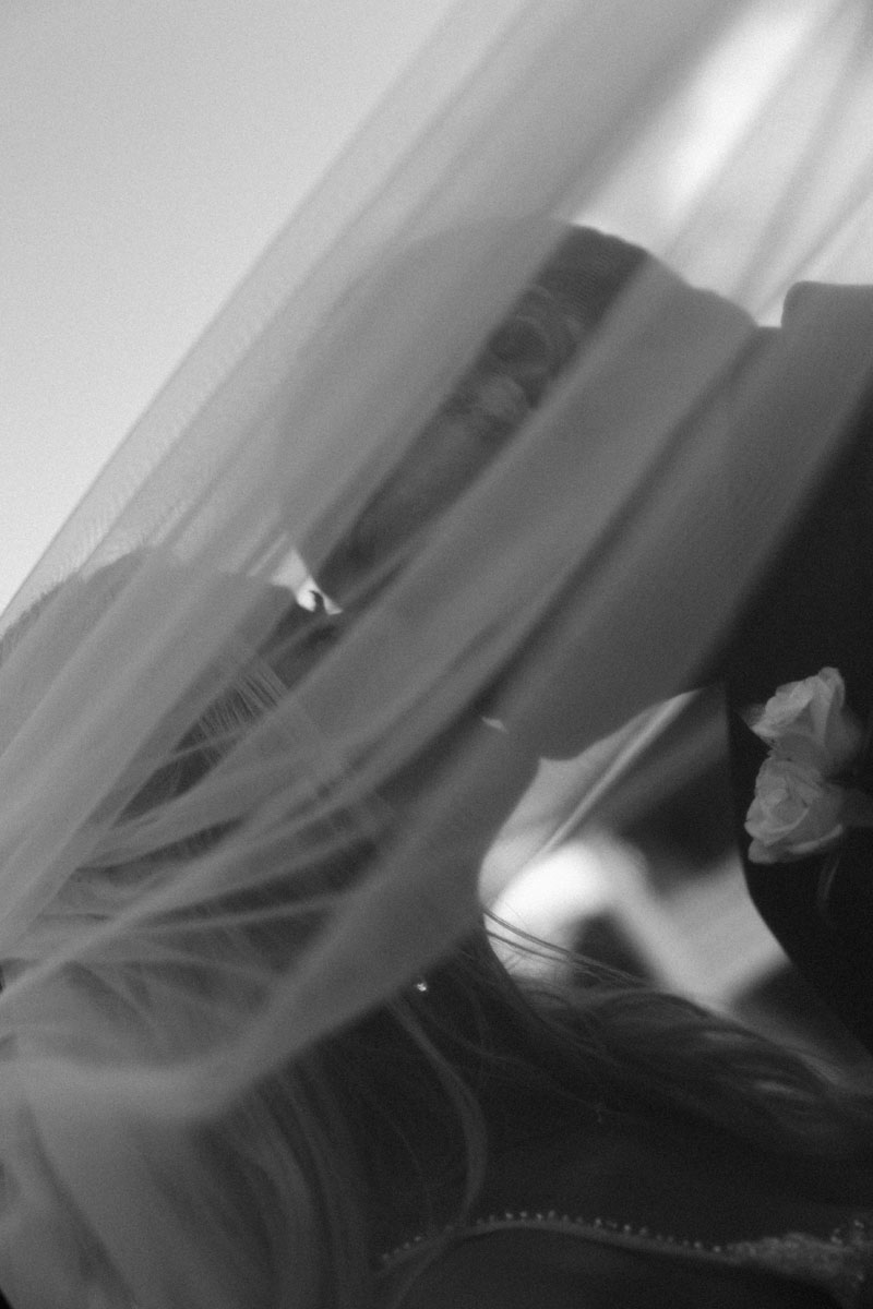 A bride and groom beneath the bride's veil