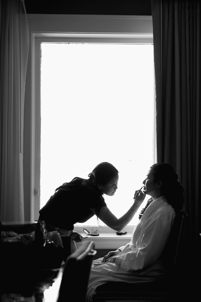 A makeup artist applying a bride's makeup