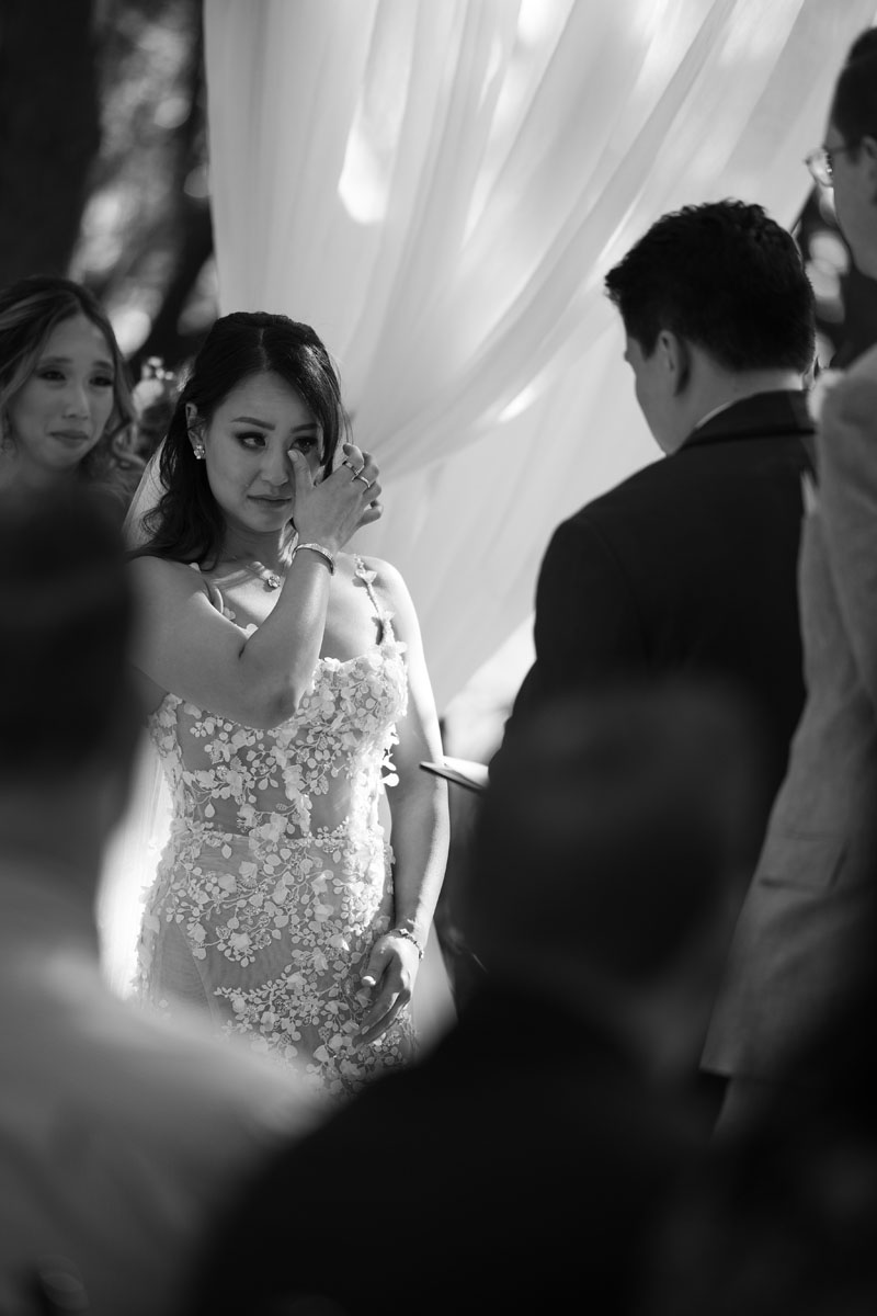 A bride wipes away a tear from her eye