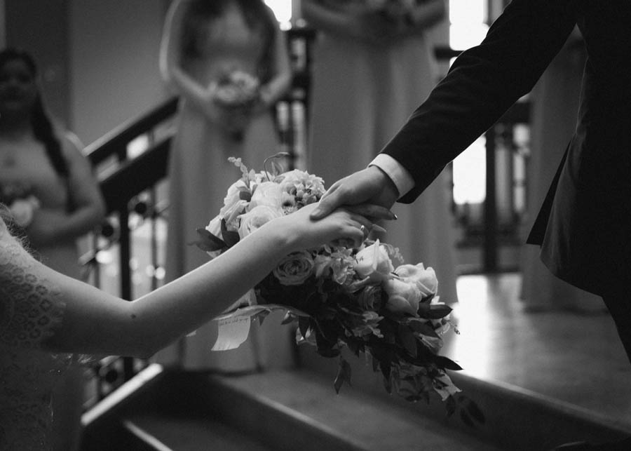 The groom's hand reaches for his wife to be