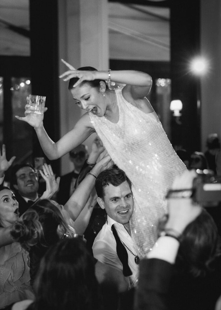 A bride is lifted high on the dancefloor