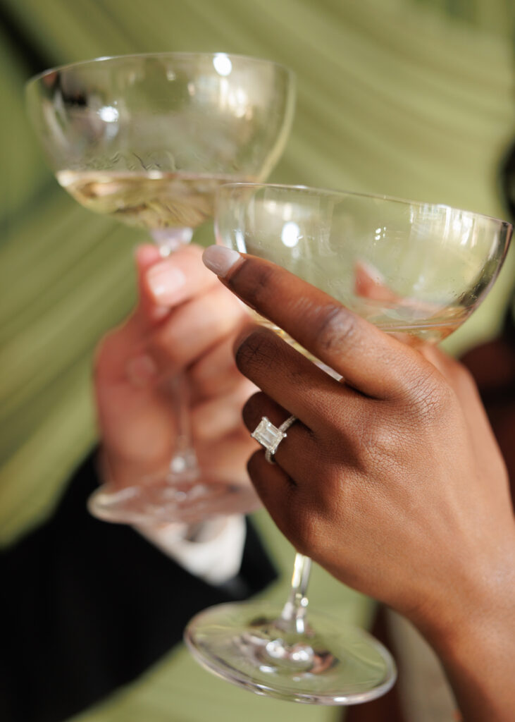 Detail of a bride and groom clinking glasses at their Texas wedding