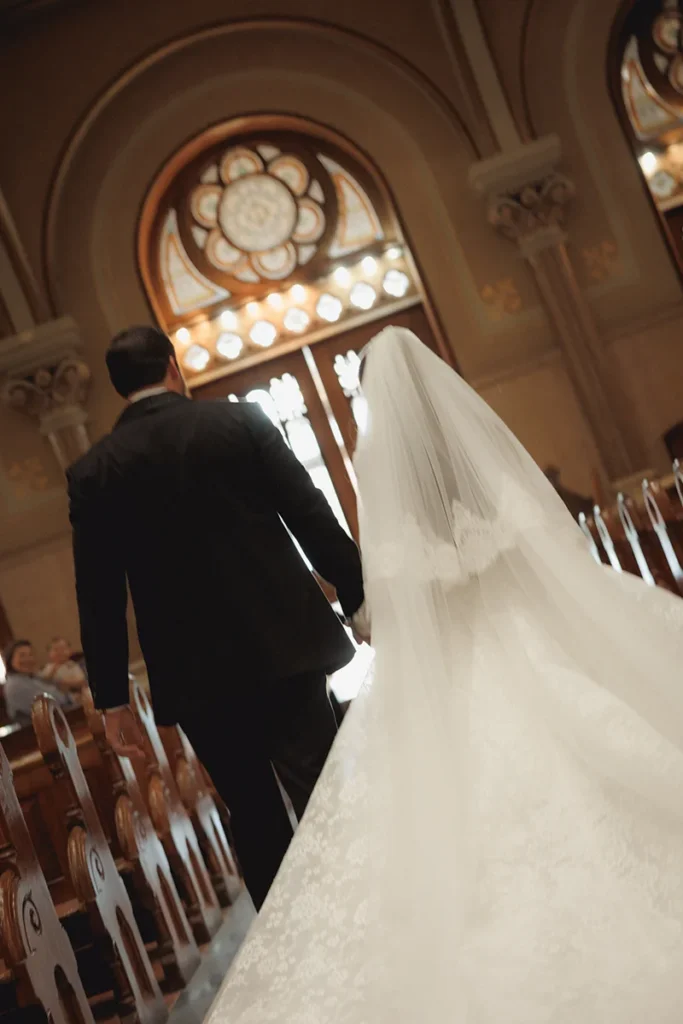 A dramatic shot of a newly married couple about to exit a beautiful church after their wedding ceremony