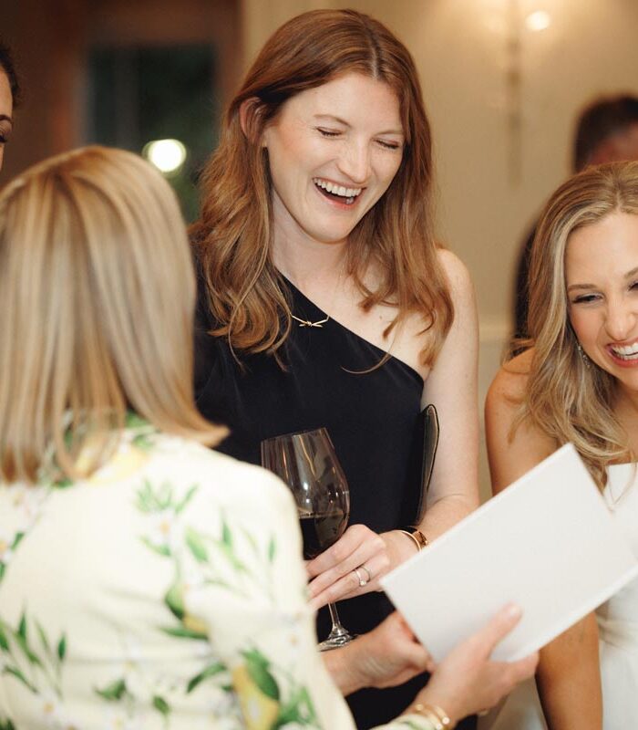 A bride-to-be laughs with guests at her wedding rehearsal dinner at Brennan's of Houston