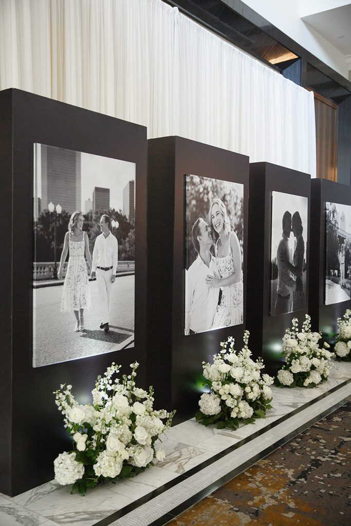 Large printed photographs of the couple at a Post Oak wedding cocktail hour