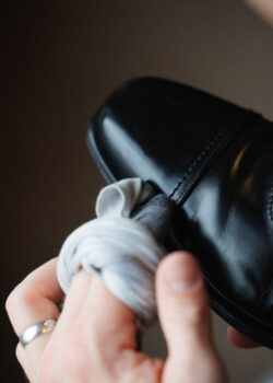 A groomsman polishes a shoe