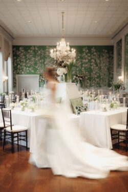 An artful, editorial, modern, shutter-dragged photograph of a bride sweeping through the room at River Oaks Country Club