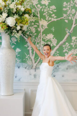 River Oaks Country Club wedding photography - the delighted bride in the dining room with the iconic green wallpaper