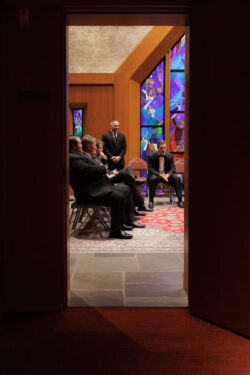 Family of the groom and groomsmen wait beyond a door in church at the Church of St. John the Divine in Houston