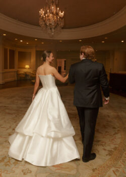 The bride and groom walk hand in hand