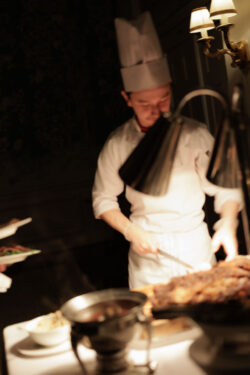A chef prepares dinner for wedding guests