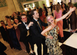 Wedding guests lead a conga line through the room at River Oaks Country Club
