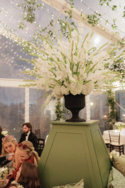 A floral centerpiece sits atop custom wedding furniture