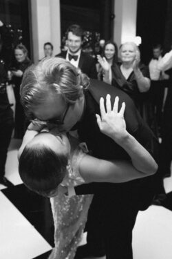 The groom dips and kisses the bride on the dancefloor