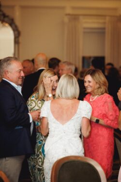 Guests laugh together at a wedding rehearsal dinner at Brennan's in Houston