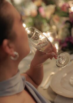 A guest drinks at dinner at a Houston Country Club wedding