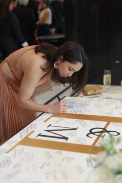 A guest signs a welcome board at a Post Oak Hotel wedding in Houston