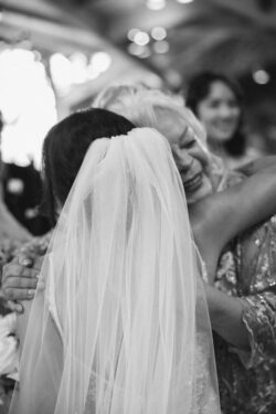 An emotional mother hugs the bride at a wedding in Texas